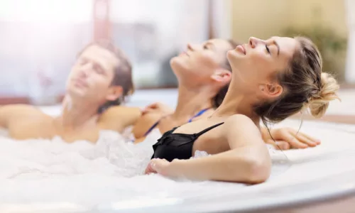 Picture showing group of friends enjoying jacuzzi in hotel spa